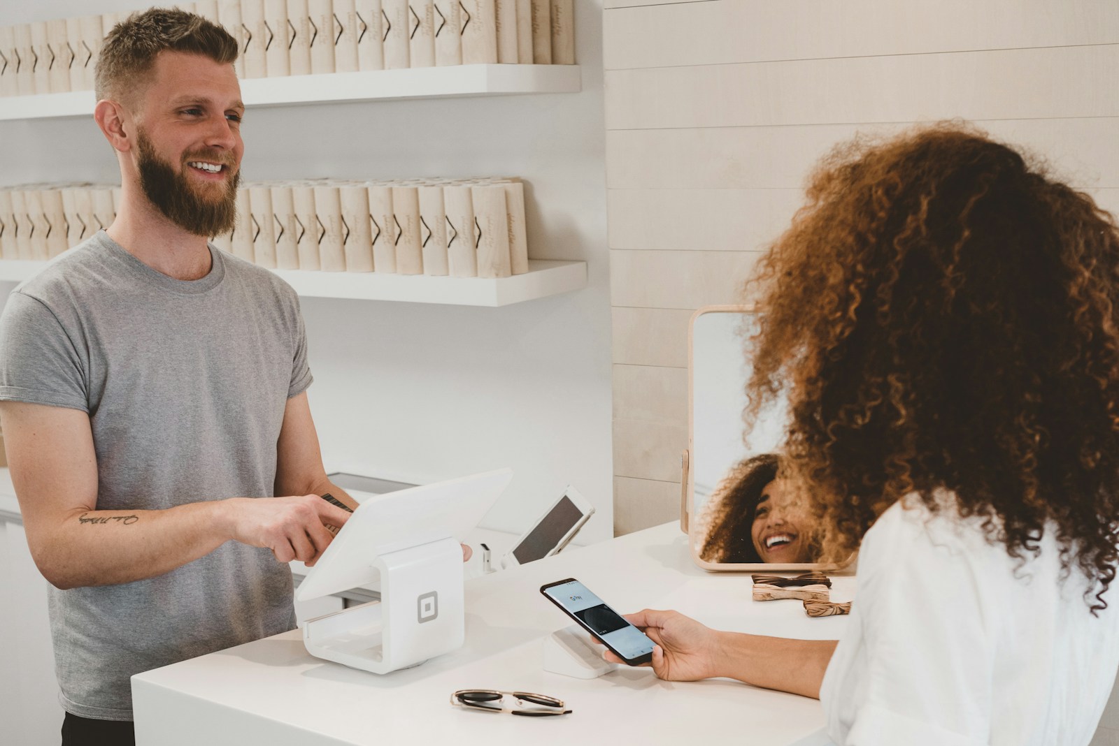 Titolare che incassa al POS mentre la cliente paga contactless